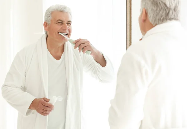 Senior man reinigen van tanden — Stockfoto