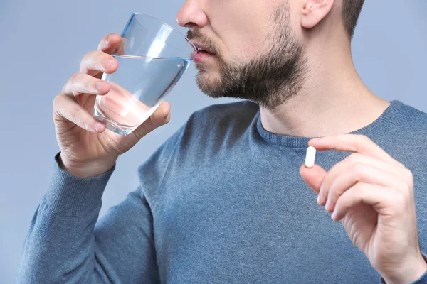 Schöner junger Mann nimmt Pille — Stockfoto