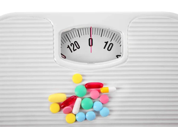 Ассорти таблеток и весы — стоковое фото