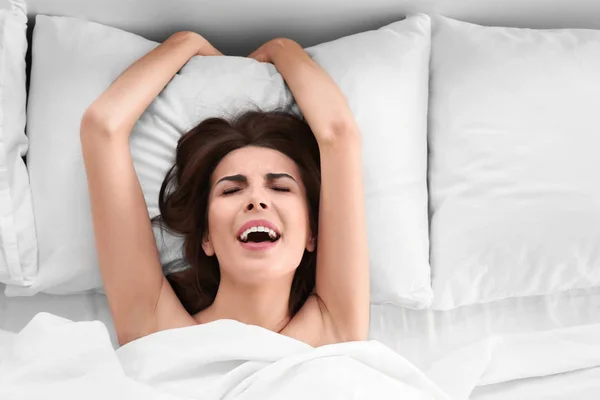 Schöne junge Frau im Bett liegend — Stockfoto