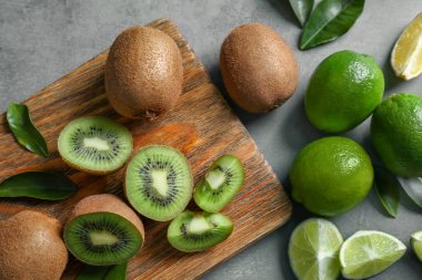 Grunge arka plan üzerinde taze limon ve kivi meyve ile ahşap kesme tahtası