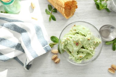 Beyaz ahşap masa lezzetli fıstıklı dondurma ile cam kase