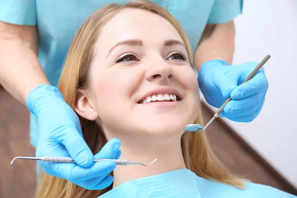 Dentist examining patient's teeth in clinic — Stock Photo, Image