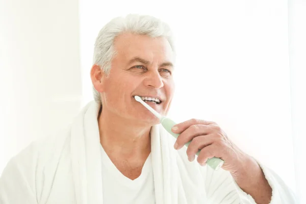 Senior man cleaning teeth