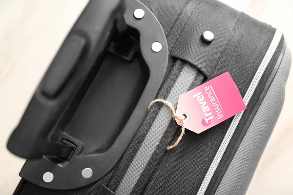 Black suitcase with label — Stock Photo, Image