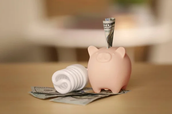 Saving electric power concept. Ceramic piggy bank with money on table