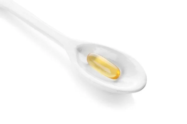 Spoon with fish oil capsule on white background — Stock Photo, Image