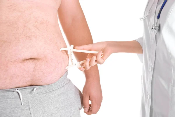Lekarz pomiaru tłuszczu na brzuchu człowieka za pomocą zacisku — Zdjęcie stockowe