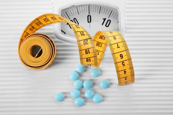 Różne tabletki i wagi — Zdjęcie stockowe