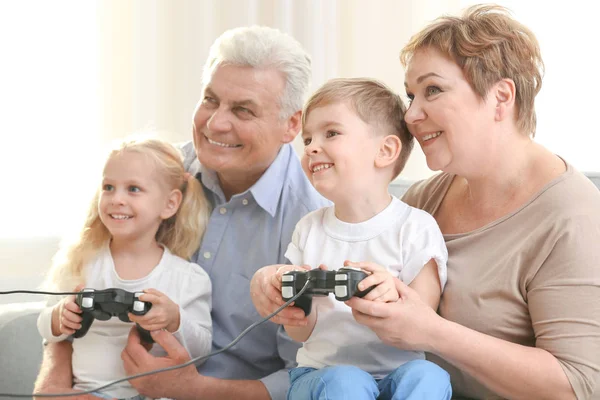 Nonni e nipoti che giocano insieme a videogiochi a casa — Foto Stock