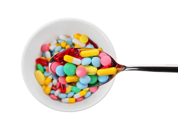 Diet concept. Spoon and bowl full of assorted pills on white background — Stock Photo, Image