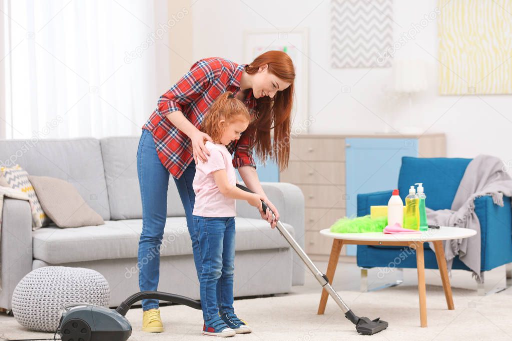 Little girl using vacuum cleaner