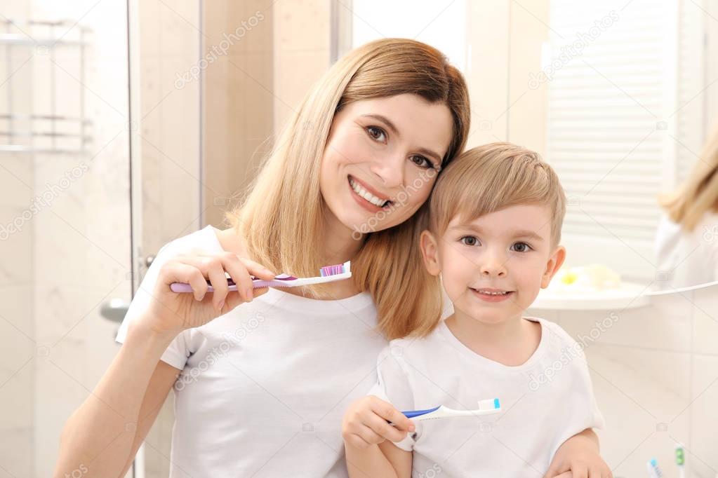 mother and happy son brushing teeth 