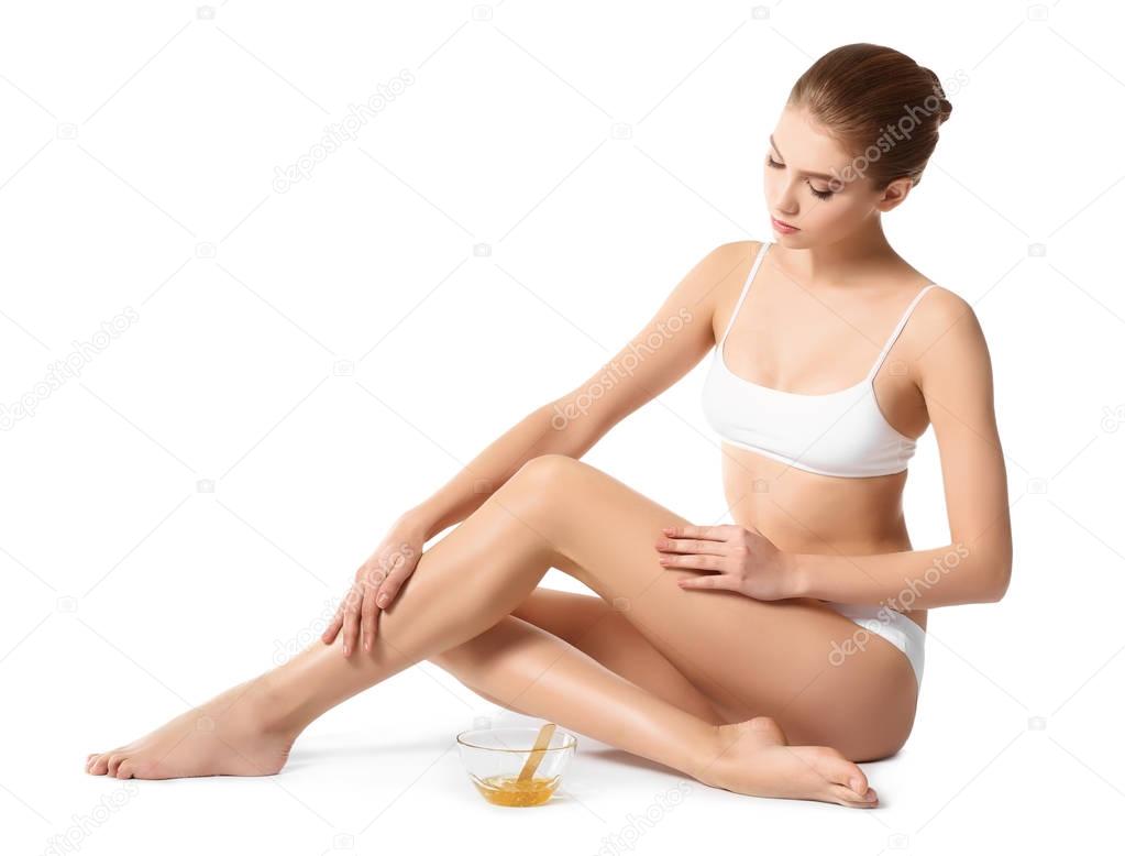 Beautiful young woman with sugaring paste on white background
