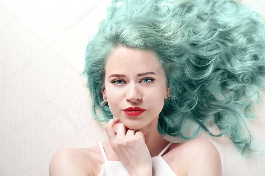 Trendy hairstyle ideas. Young woman with mint hair color on wooden background