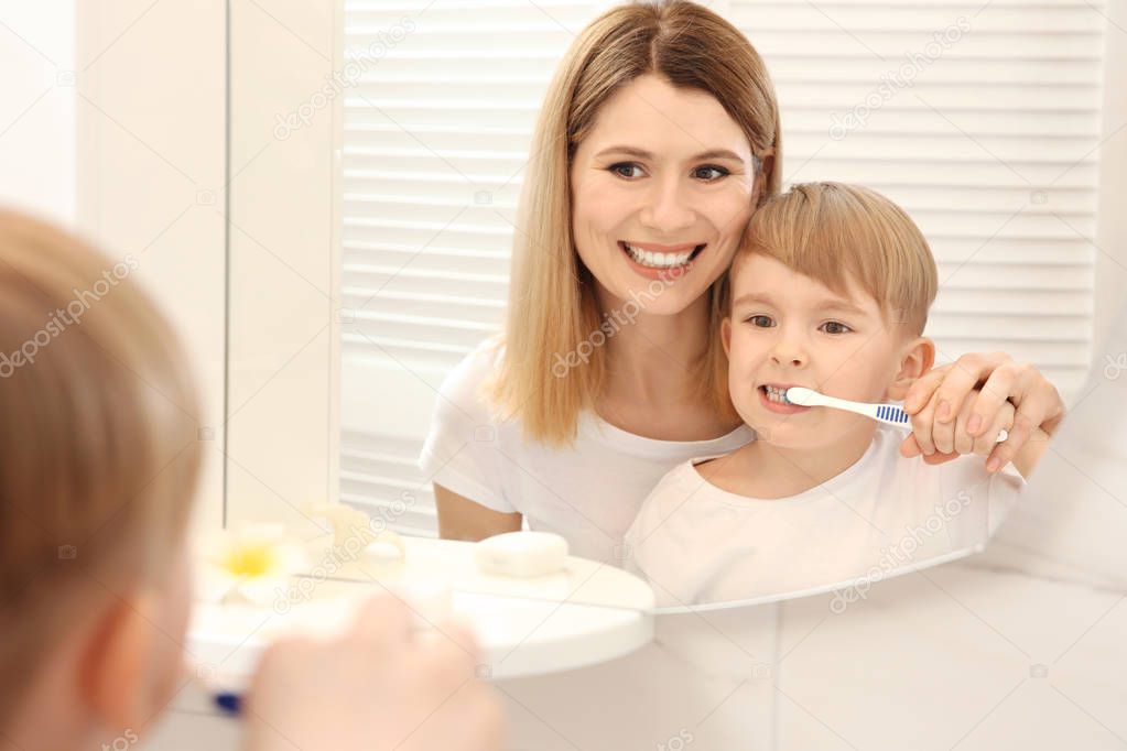 mother and happy son brushing teeth 