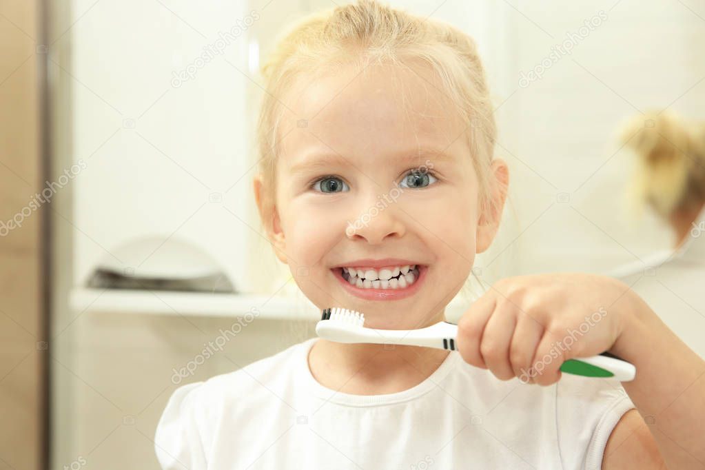 Little girl holding toothbrush 