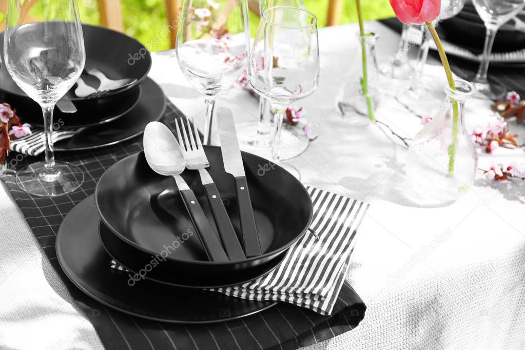 Plates with cutlery on served festive table