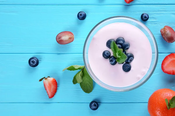 Komposisi dengan yogurt buatan sendiri yang lezat dan bahan-bahan pada latar belakang biru — Stok Foto