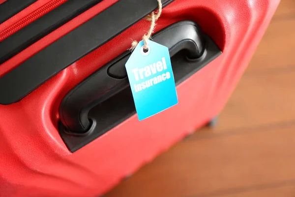 Red suitcase with label — Stock Photo, Image