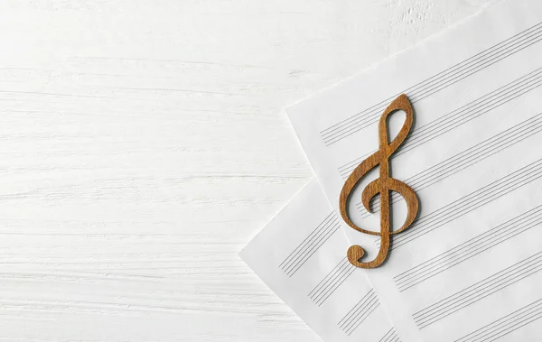 Деревянный музыкальный клиф лежал на нотах — стоковое фото