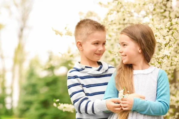 Досить маленька дівчинка і милий хлопчик ходить у весняному парку — стокове фото