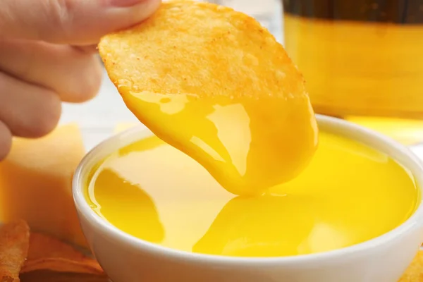 Sumergiendo las papas fritas en un tazón con salsa de queso cremoso, de cerca — Foto de Stock