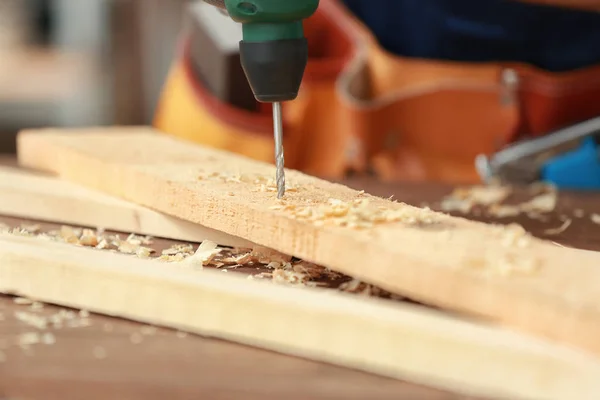 Плотник сверлит деревянную доску — стоковое фото