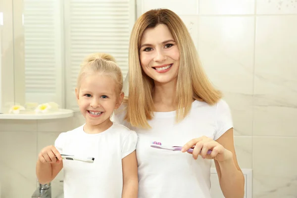 Bambina con madre lavarsi i denti — Foto Stock