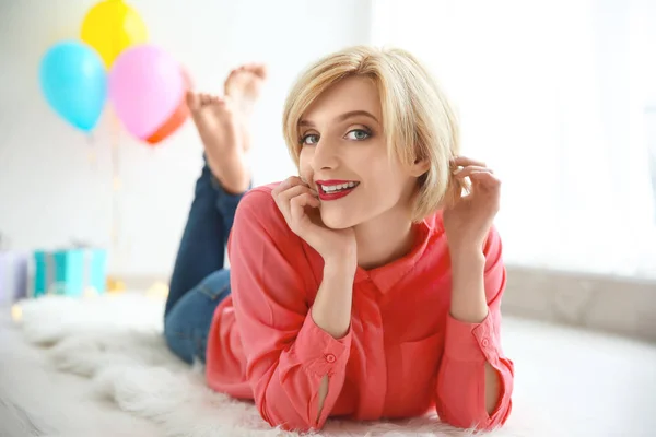 Mooie vrouw liggend op de vloer op verjaardagsfeestje — Stockfoto