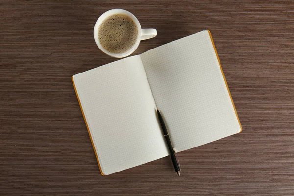 Notebook with pen and cup of coffee — Stock Photo, Image