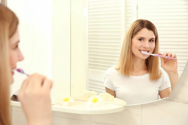 Jeune femme brossant les dents — Photo