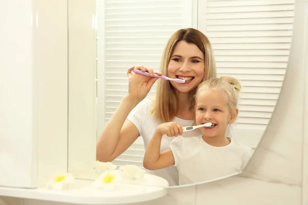 Menina com a mãe escovar os dentes — Fotografia de Stock