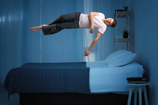 Parálisis del sueño. Joven levitando sobre la cama — Foto de Stock