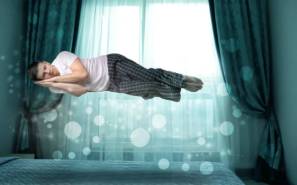 Koncepcja snu paraliż. Młody człowiek Lewitujący nad łożem — Zdjęcie stockowe