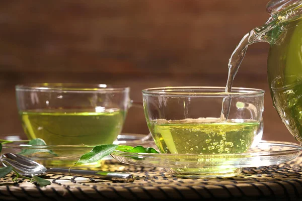 Налить зеленый чай в стеклянную чашку — стоковое фото