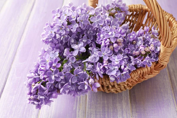 Cesta de vime com flores lilás — Fotografia de Stock