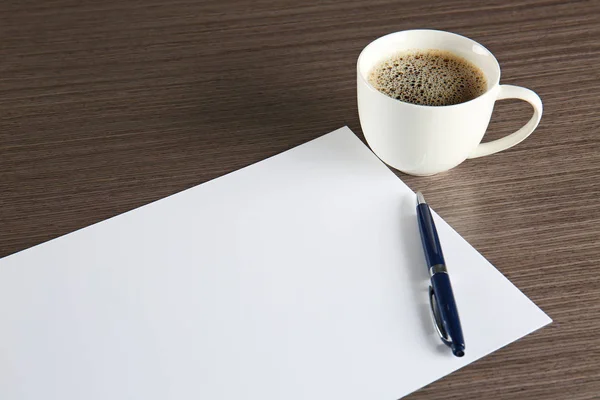 Papierbogen mit Stift und Tasse Kaffee lizenzfreie Stockbilder