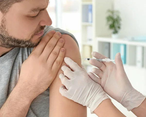 Лікар вакцинація молодого чоловіка — стокове фото