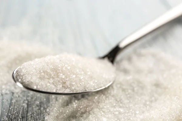 Spoon with sugar on table — Stock Photo, Image