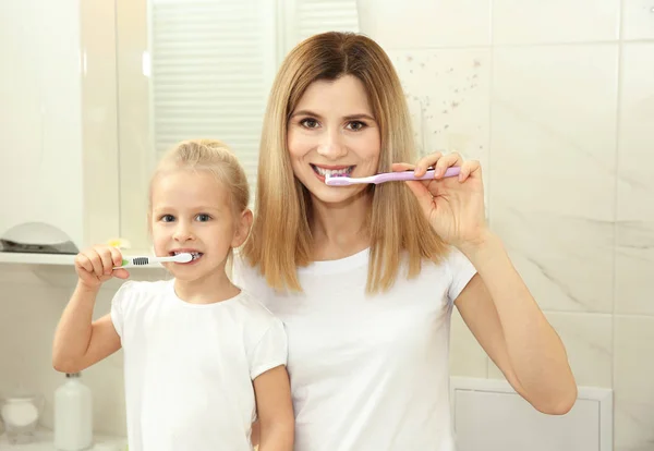 Menina com a mãe escovar os dentes — Fotografia de Stock