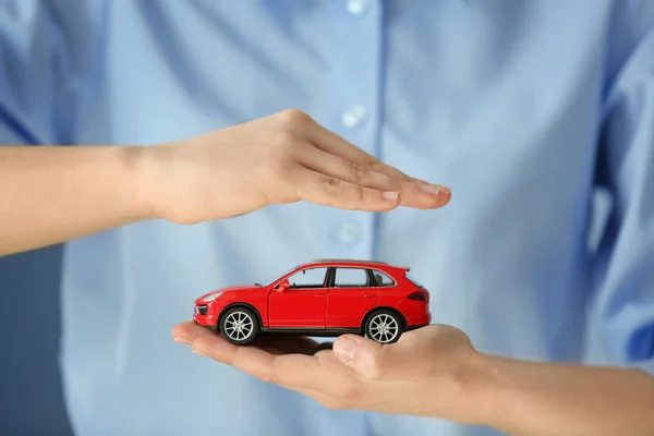 Mujer sosteniendo modelo de coche — Foto de Stock