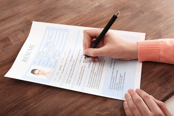 Frau füllt Lebenslauf-Formular auf Tisch aus. — Stockfoto