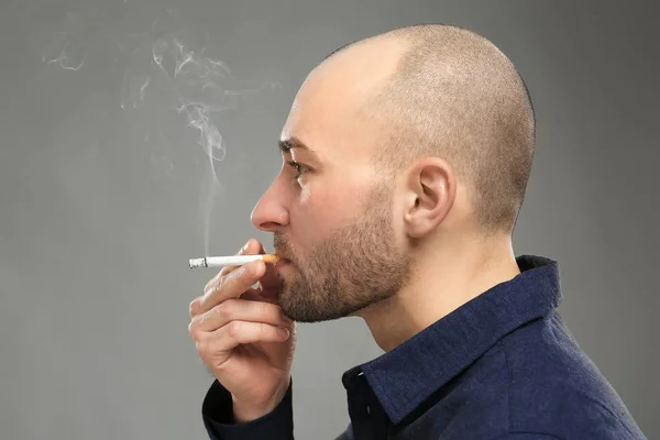 Красивий чоловік курить сигарету — стокове фото