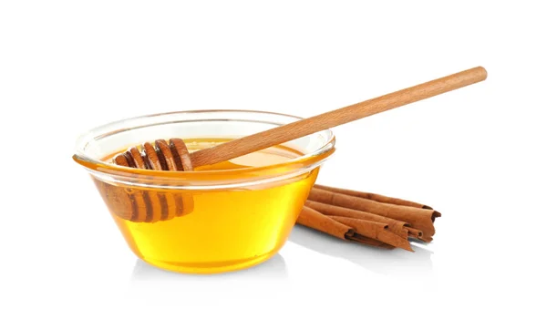Kaneelstokjes en honing in glazen kom — Stockfoto