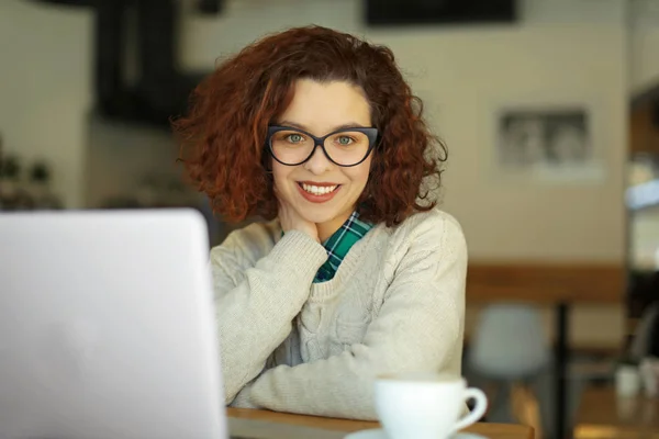 Όμορφο κορίτσι με laptop και ζεστό ρόφημα στο καφέ — Φωτογραφία Αρχείου