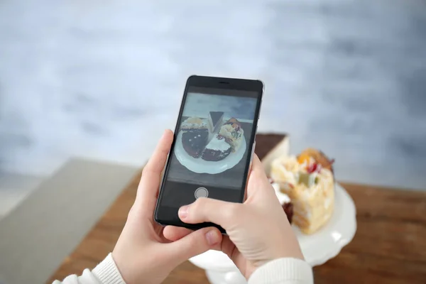 Händer fotografera kakor med mobiltelefon — Stockfoto