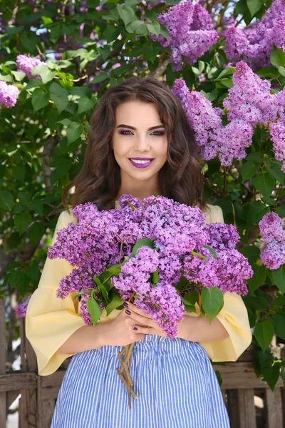 ライラックの花束と美しい若い女性 — ストック写真