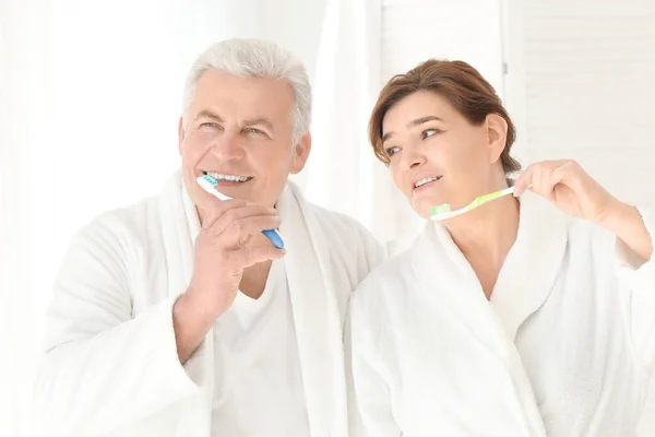 Pareja mayor limpiando dientes — Foto de Stock