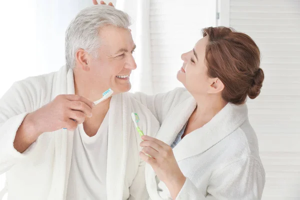 Pareja mayor limpiando dientes — Foto de Stock